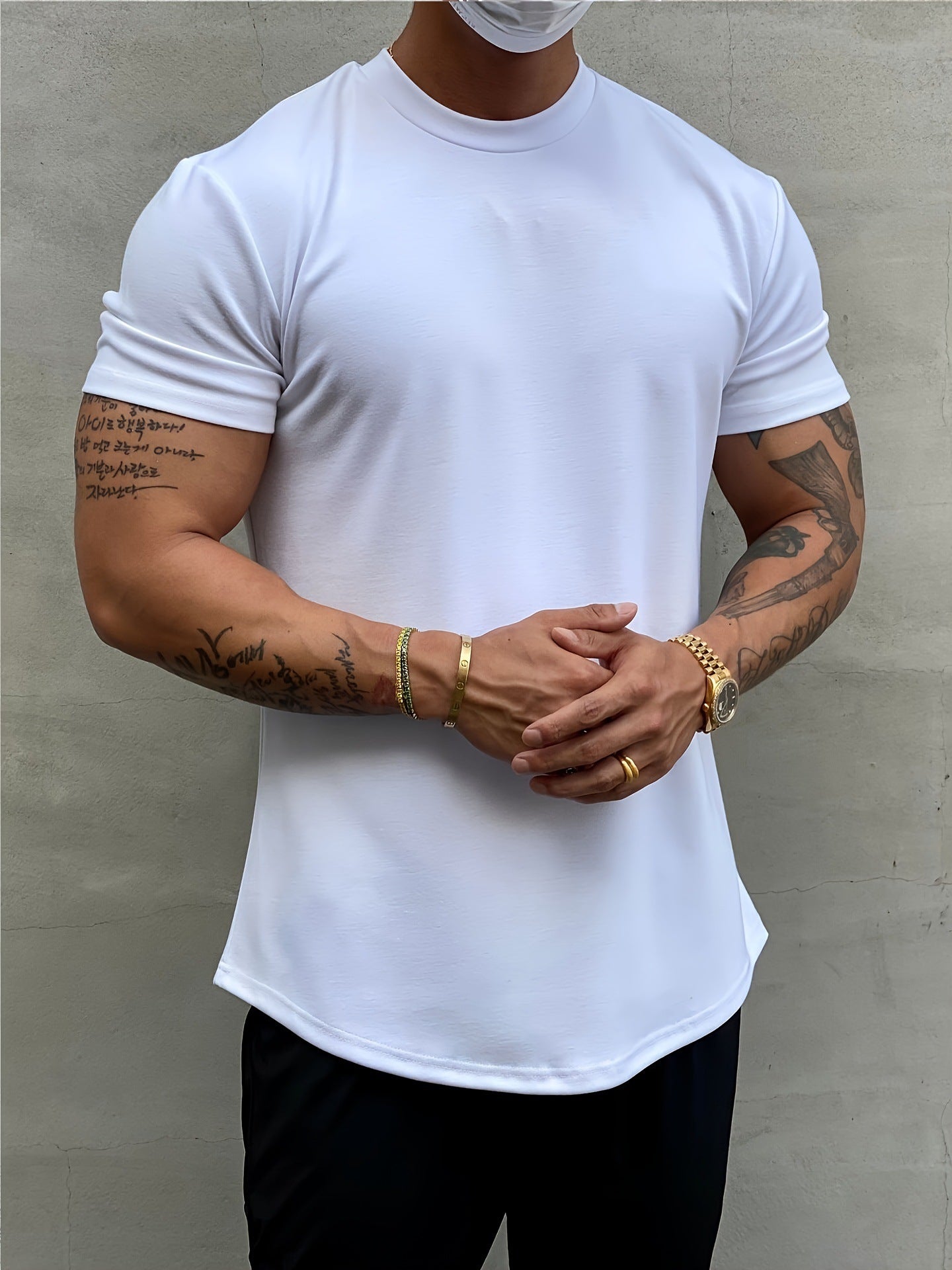 Person wearing a plain white t-shirt against a gray background