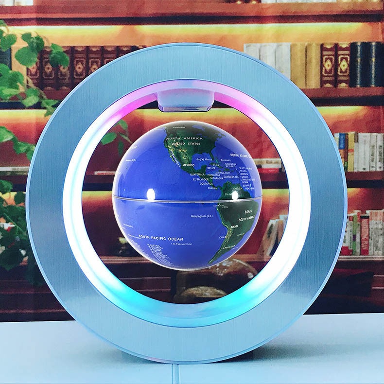 Levitating globe with colorful light ring on a table