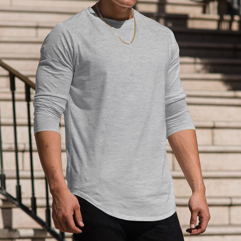 Person wearing a gray long-sleeve shirt standing outdoors on steps.