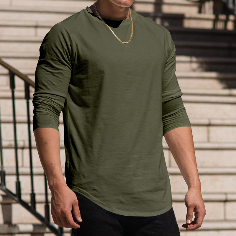 Person wearing a green long-sleeve shirt standing on steps.