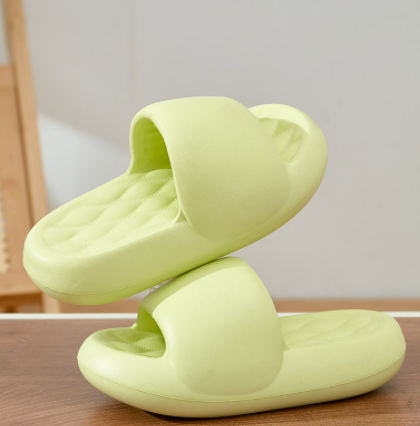 Light green slippers on a wooden surface with a neutral background
