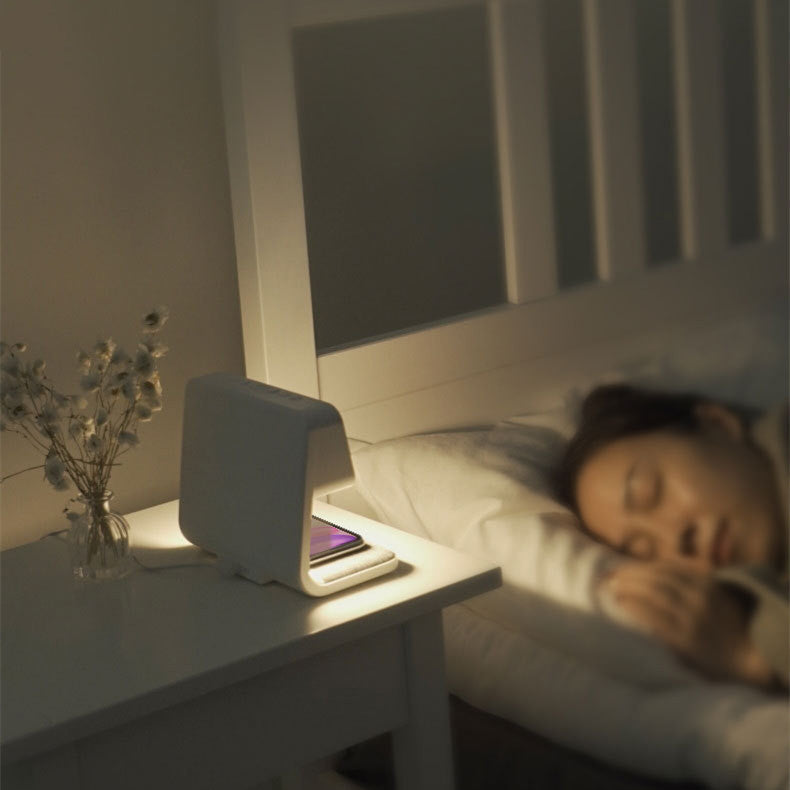 Woman sleeping in bed with a nightstand lamp on a nightstand next to her.
