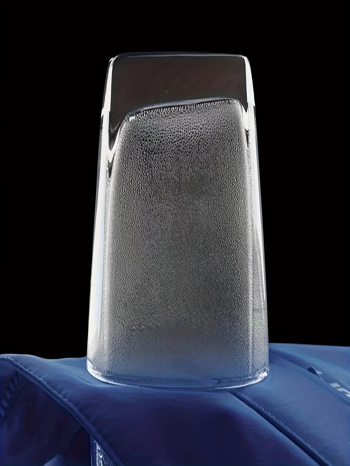 Clear glass vase on a blue surface with a black background