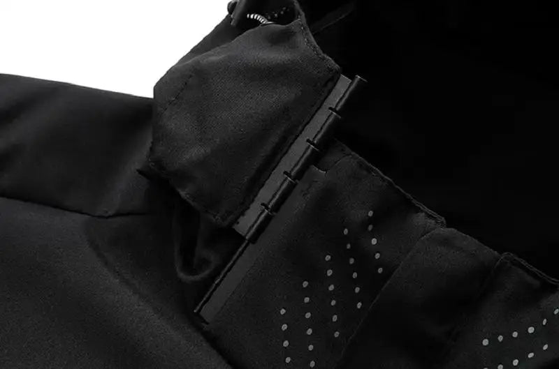 Close-up of a black coat with a zipper and button details on a dark background
