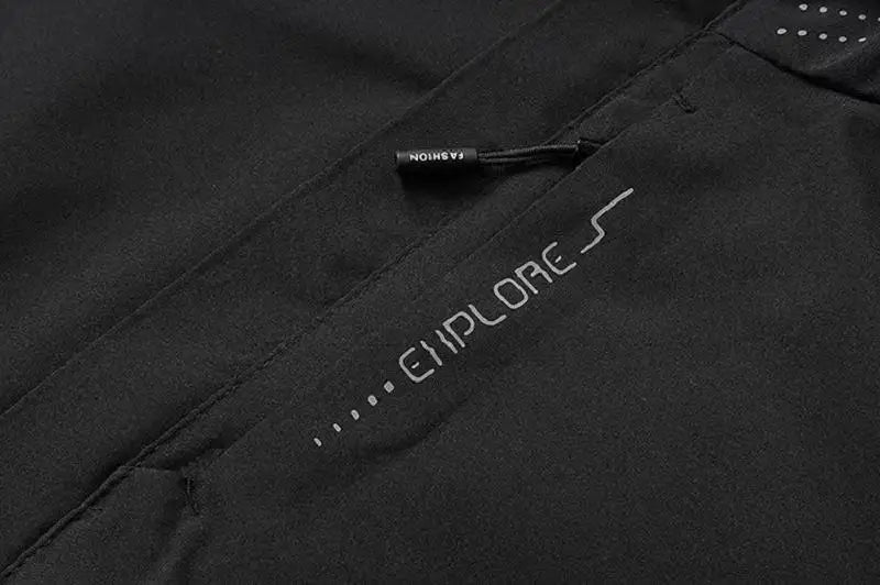 Close-up of a black jacket with 'EXPLORE' branding on a dark background