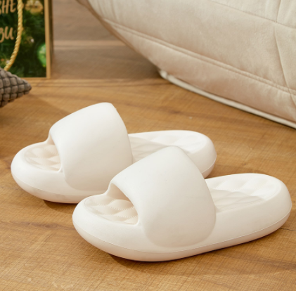Pair of white slippers on a wooden floor with a blurred background