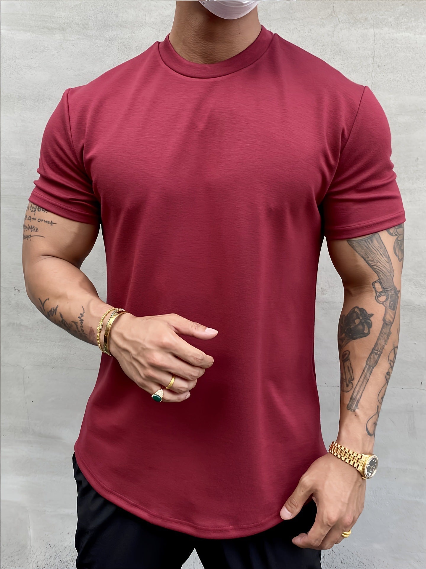 Person wearing a maroon t-shirt against a gray background