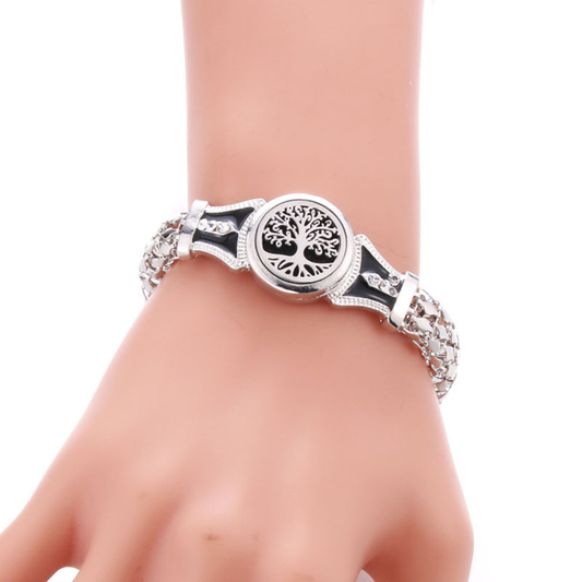 Silver bracelet with tree of life design on a wrist against a white background