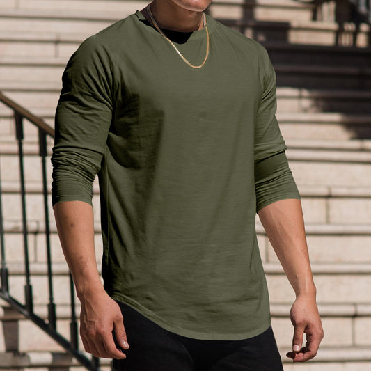 Person wearing a green long-sleeve shirt standing on steps.