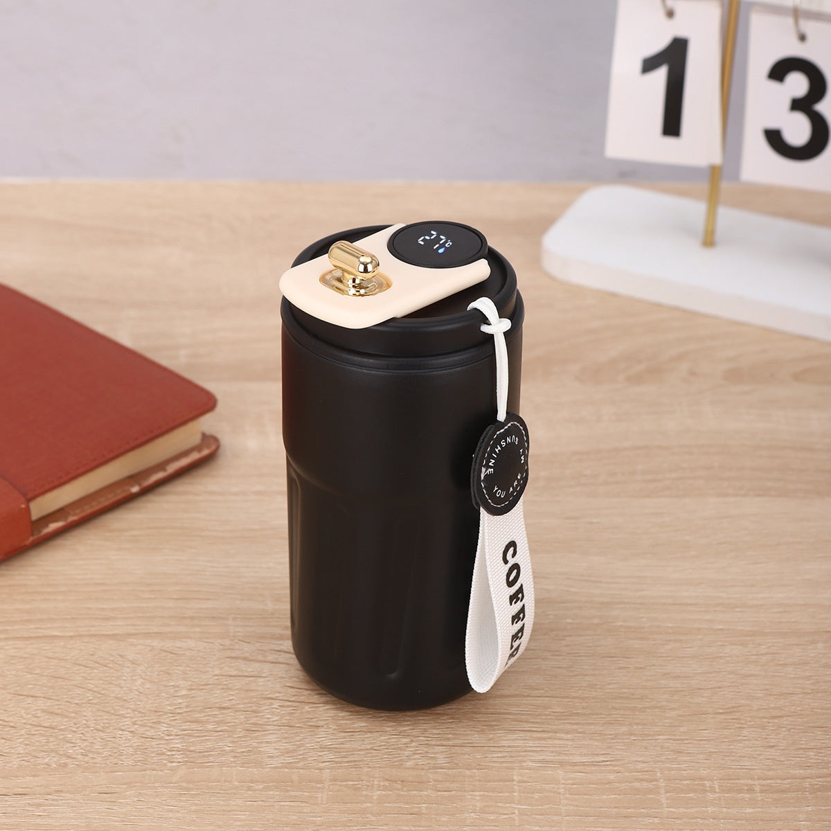 Black coffee thermos with digital display on a wooden surface