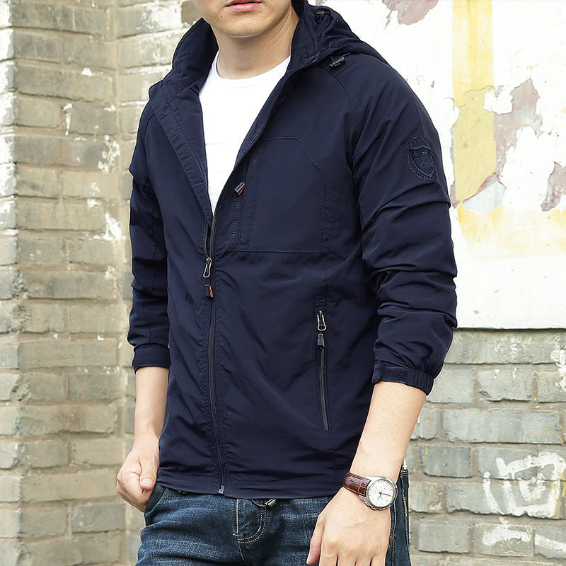 Person wearing a navy blue jacket in front of a textured wall.